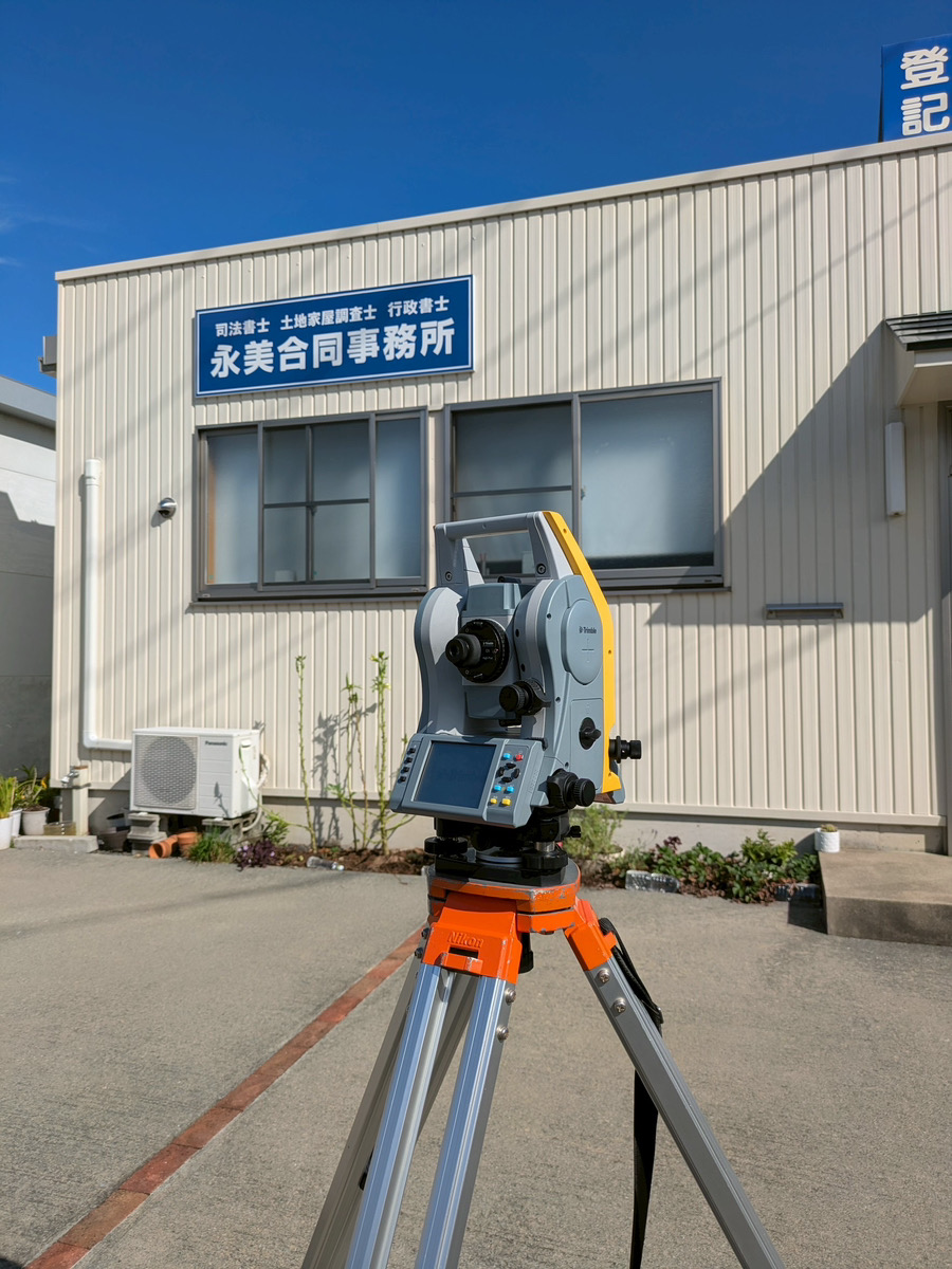 青いパーテーションで区切られた、多数のデスクとパソコンが並ぶ広々としたオープンオフィス